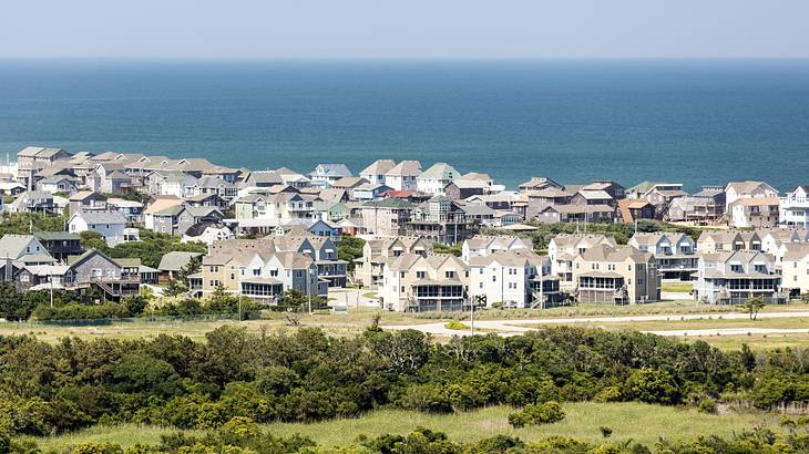 View of beach houses, shrubbery and water from atop a high point