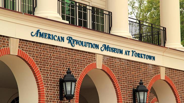Blue text of "American Revolution Museum at Yorktown" on a building with arches