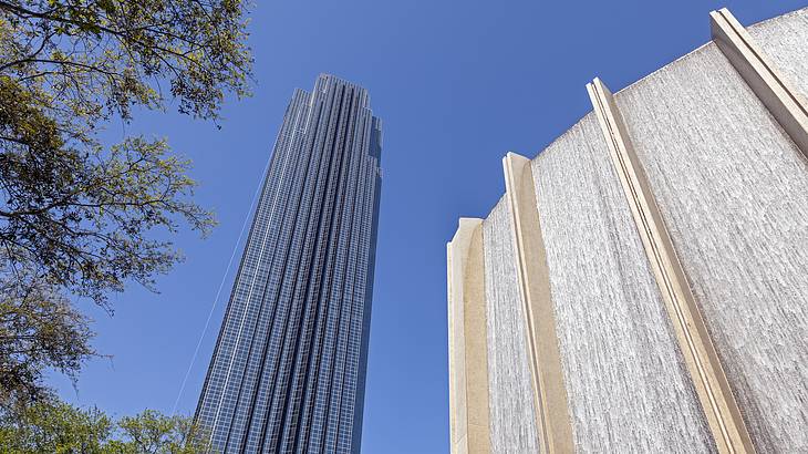 A tall tower beside a manmade waterfall and trees