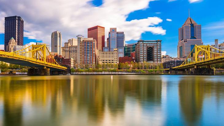 A river with buildings on the shore and a bridge on both sides of it