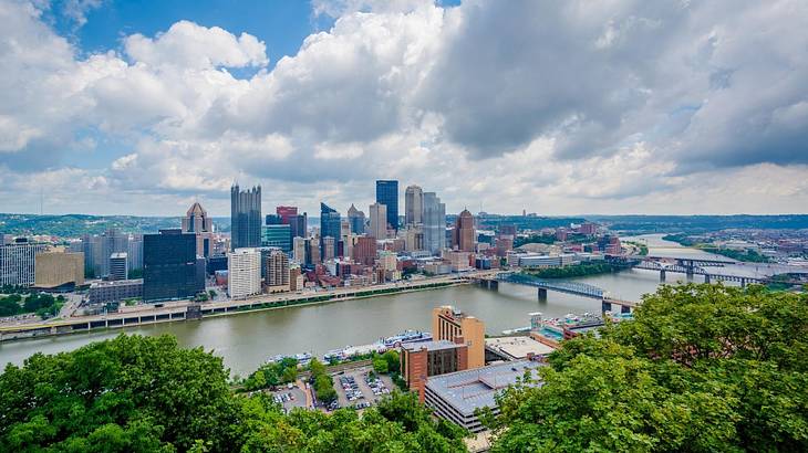 A city skyline as seen from a lookout, under a cloudy sky