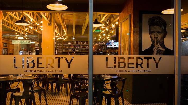 The glass front of a restaurant with a "Liberty Food & Wine Exchange" sign