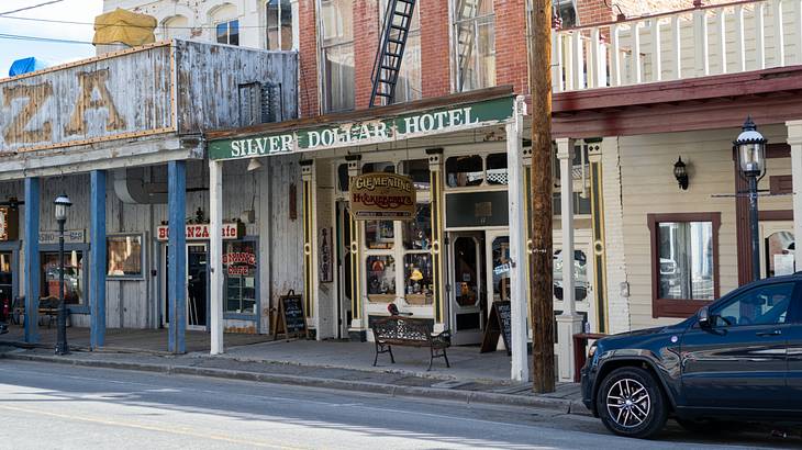 Old-fashioned buildings with signs on them next to a road