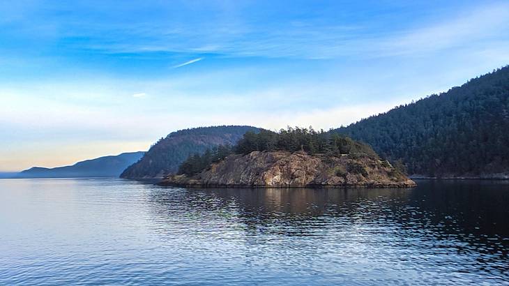 Ocean water with cliffs in the distance under a blue sky