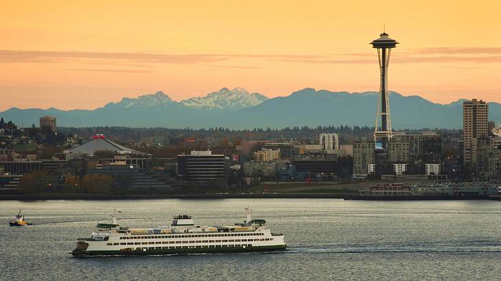 A skyline with many skyscrapers and a lake in front of it at sunset