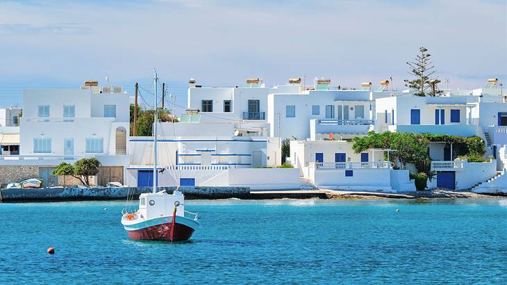 A fishing boat in the sea near a coast with white houses