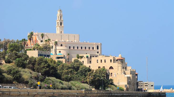 A church on a lush hilly terrain near a road and a beach