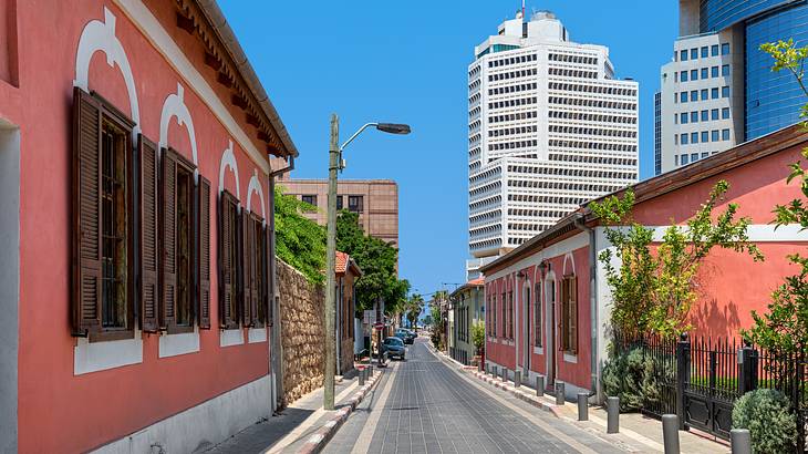 An alley surrounded by colorful buildings with skyscrapers in the distance