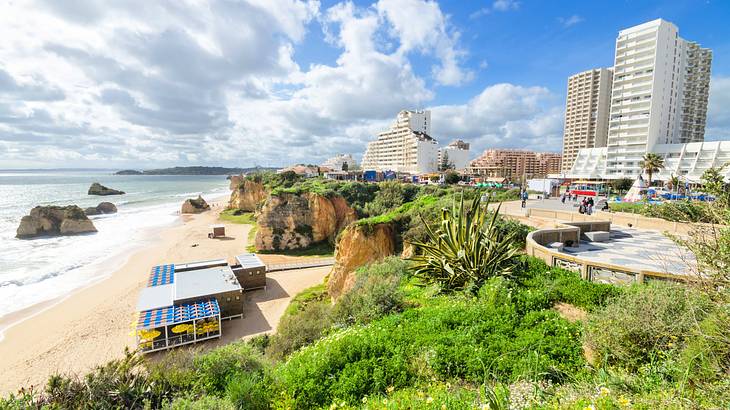 A beachside with cliffs, rock formations, and tall buildings