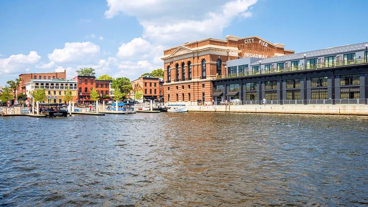 Old and new buildings near a body of water under a blue sky with white clouds