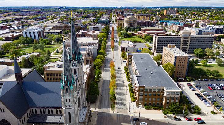 An aerial shot of a city with roads, buildings, and a cathedral with two towers