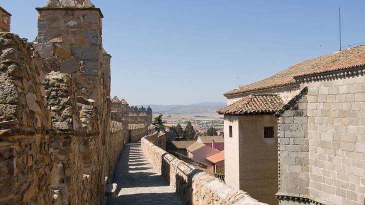 A stone path in between old fort walls on a clear blue day