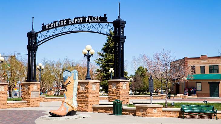 A cowboy boot statue and a black arch that says "Cheyenne Depot Plaza"