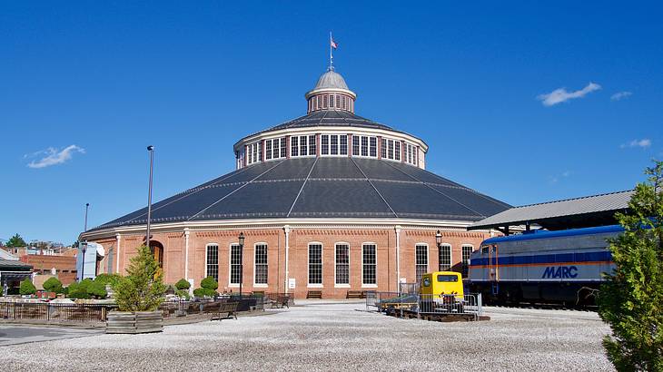 A circular building with a pointy top in the middle next to a wide pathway