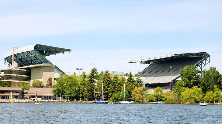 A stadium with retractable roof near trees and a body of water