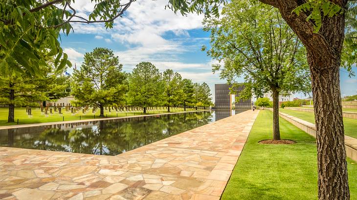 An artificial body of water in the middle of a landscaped area surrounded by trees