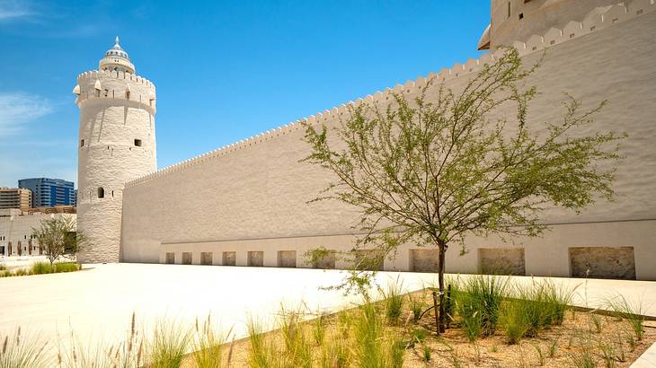 The outside wall of an old fort with a watchtower on the left The outside wall of an old fort with a watchtower on the left