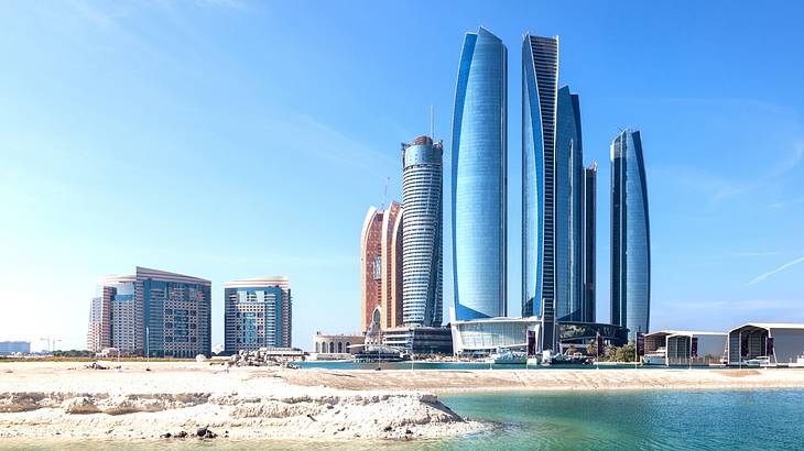 A skyline full of tall skyscrapers with water in front A skyline full of tall skyscrapers with water in front