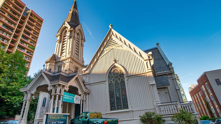 A Gothic-style church with a sign and a truck in front