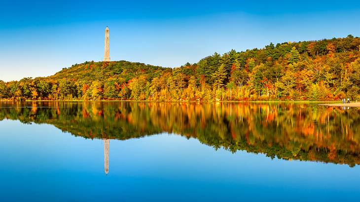 Lush mountains with their reflection on the nearby lake during fall