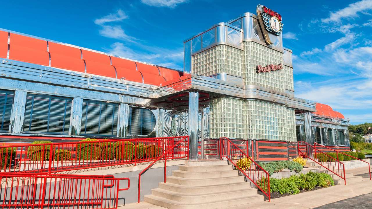 A retro diner facade next to concrete stairs with red railings
