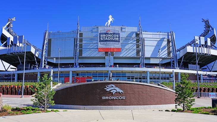 A facade of a stadium with logos and signage saying "Broncos Stadium"