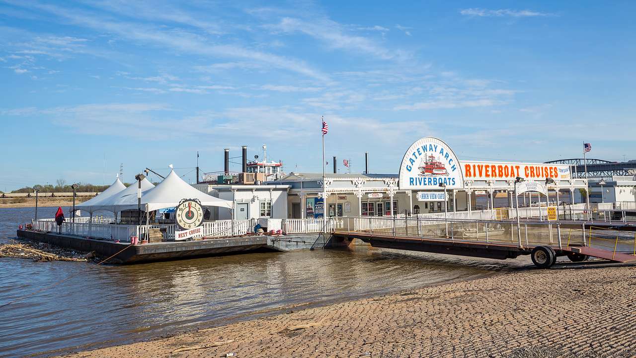 An inland river port with white tents and a sign saying "Riverboat Cruises"