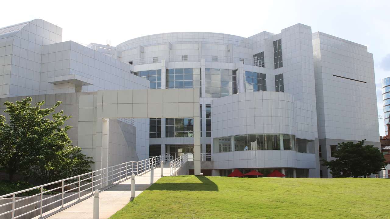 A modern white building with a path and patch of grass in front of it