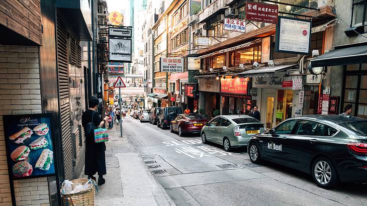 A street lined with shops and cars in Hong Kong