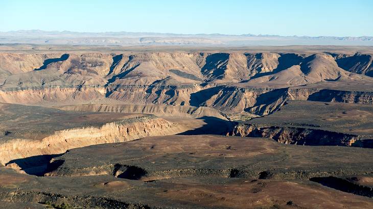 A rugged canyon landscape on a clear blue day from above A rugged canyon landscape on a clear blue day from above