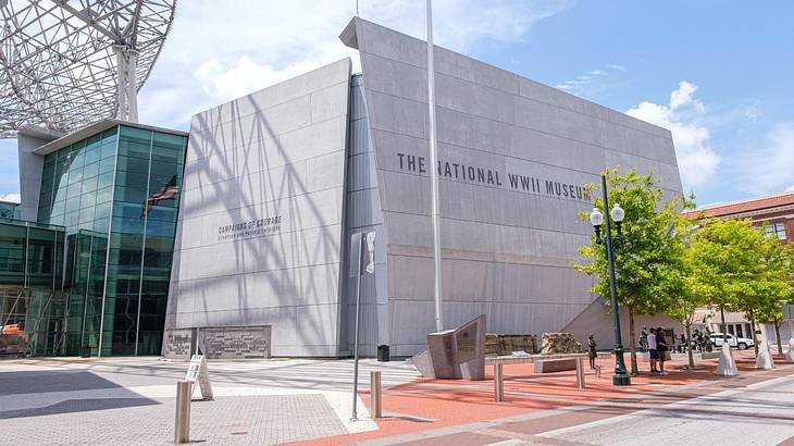 A modern gray concrete and glass building with the text "The National WWII Museum"
