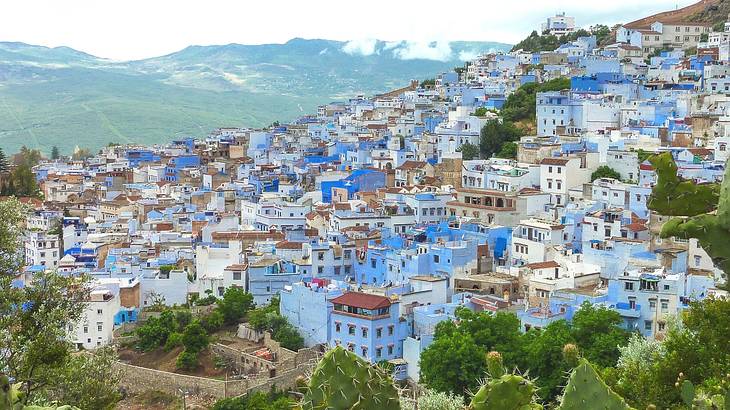 A panoramic view of white and blue houses surrounded by mountains A panoramic view of white and blue houses surrounded by mountains