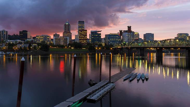 A city skyline at night with a lake in front of it