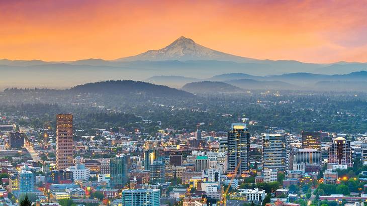 An aerial view of a city and mountains at sunset