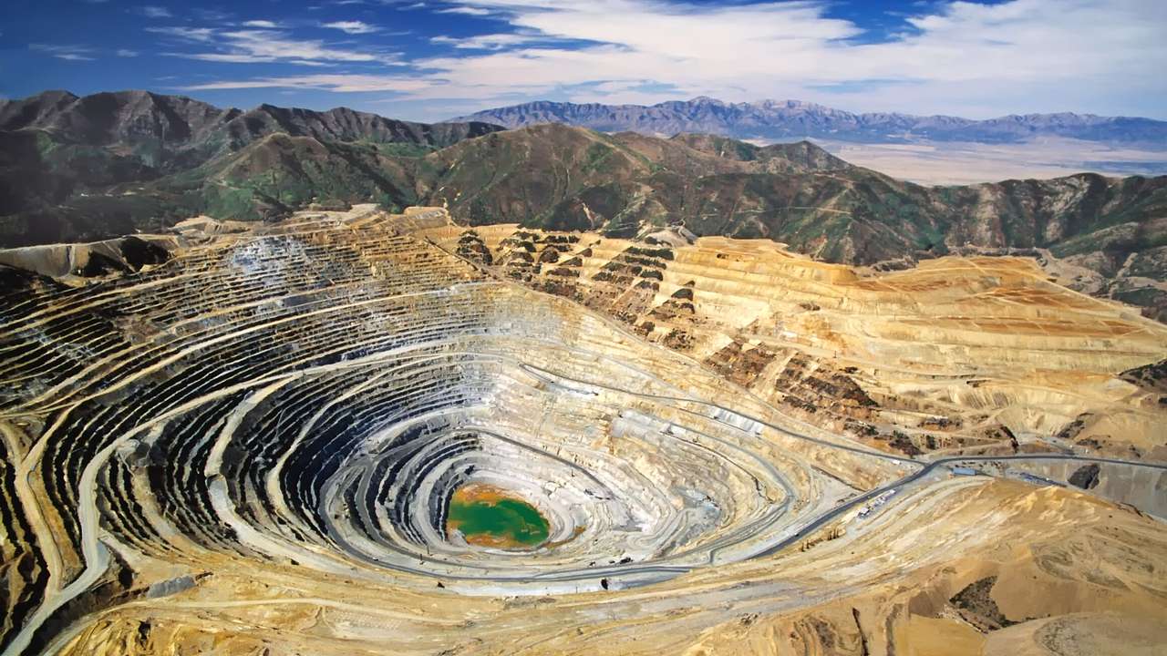 An aerial view of a circular mine with mountains surrounding it