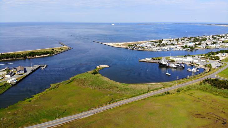 A view over an inlet with some boats on it next to grass and houses