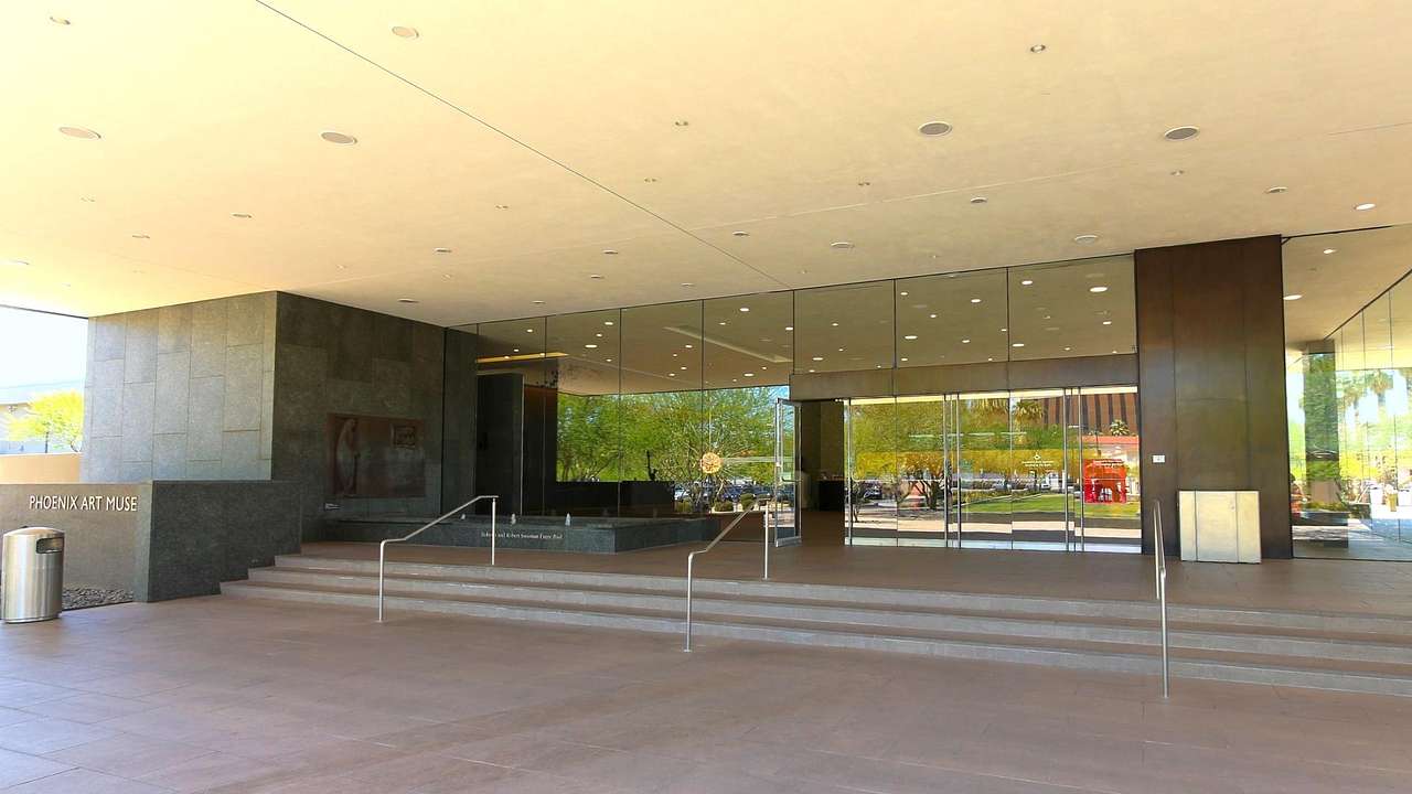 Looking towards stairs leading to the glass door entrance of a museum