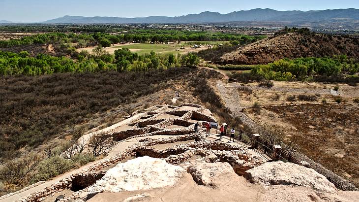 A limestone and sandstone ridge with stone ruins and mountains at the back