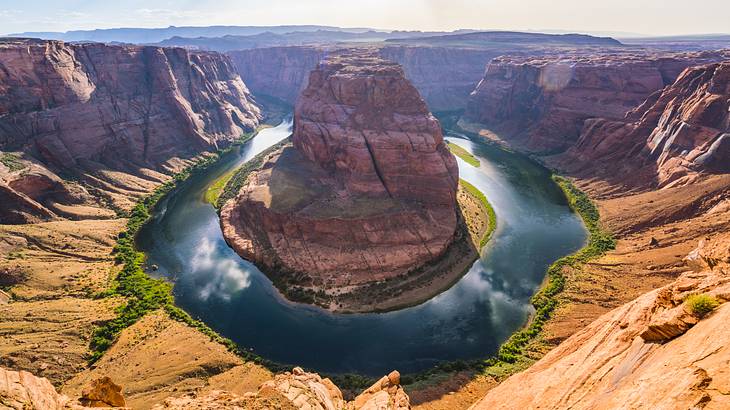 A river meandering through a horseshoe-shaped red rock formation