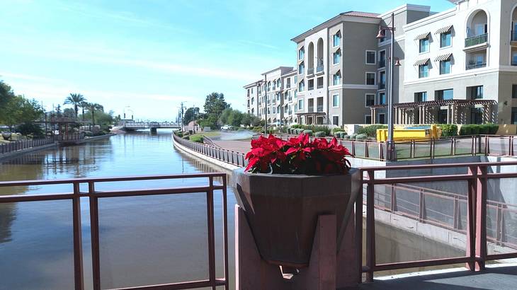 Gray buildings lined up facing a canal and a pedestrian bridge