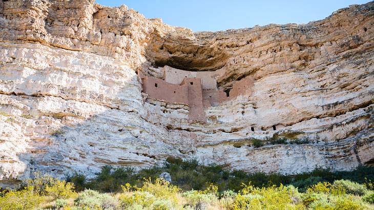 A castle-like dwelling in a white cliff under a clear sky