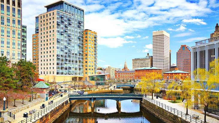 A waterway with buildings surrounding it under a blue sky with clouds