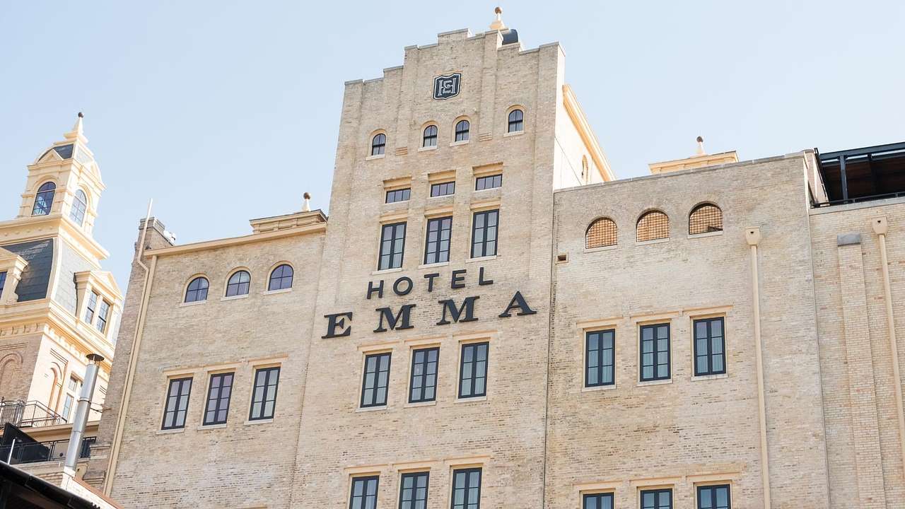 A hotel building with a tower in the middle and a "Hotel Emma" sign