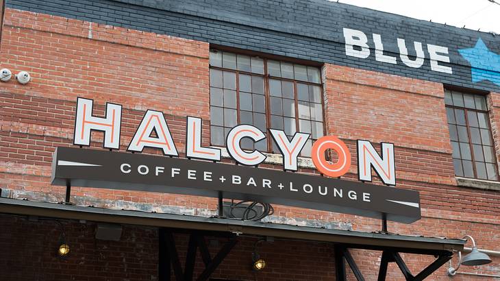 A red-brick building with a signboard saying "Halcyon Coffee+Bar+Lounge"