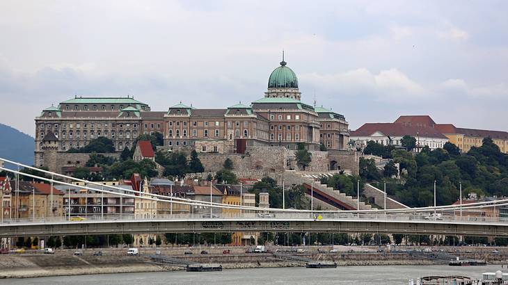 A panoramic shot of Buda Castle behind a bridge from across a river, Budapest