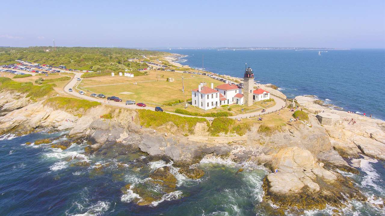 Aerial shot of a headland with a lighthouse near the ocean