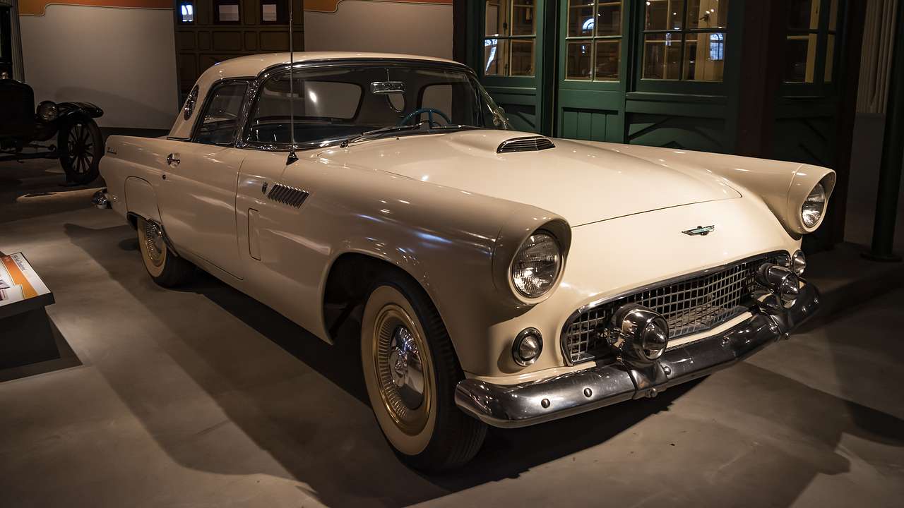 A classic white convertible car inside a museum