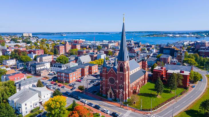 Building with a blue steeple, and other buildings, roads, trees, and water around