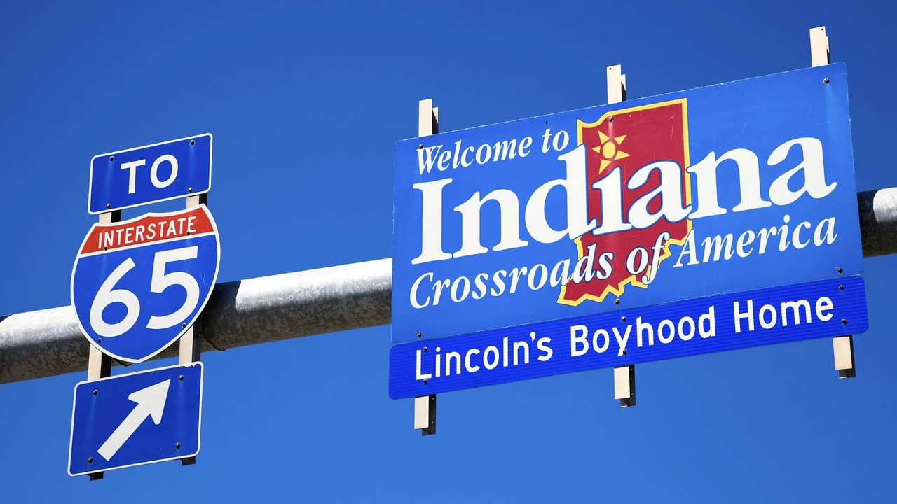 Blue highway signs saying "Welcome to Indiana, Crossroads of America"