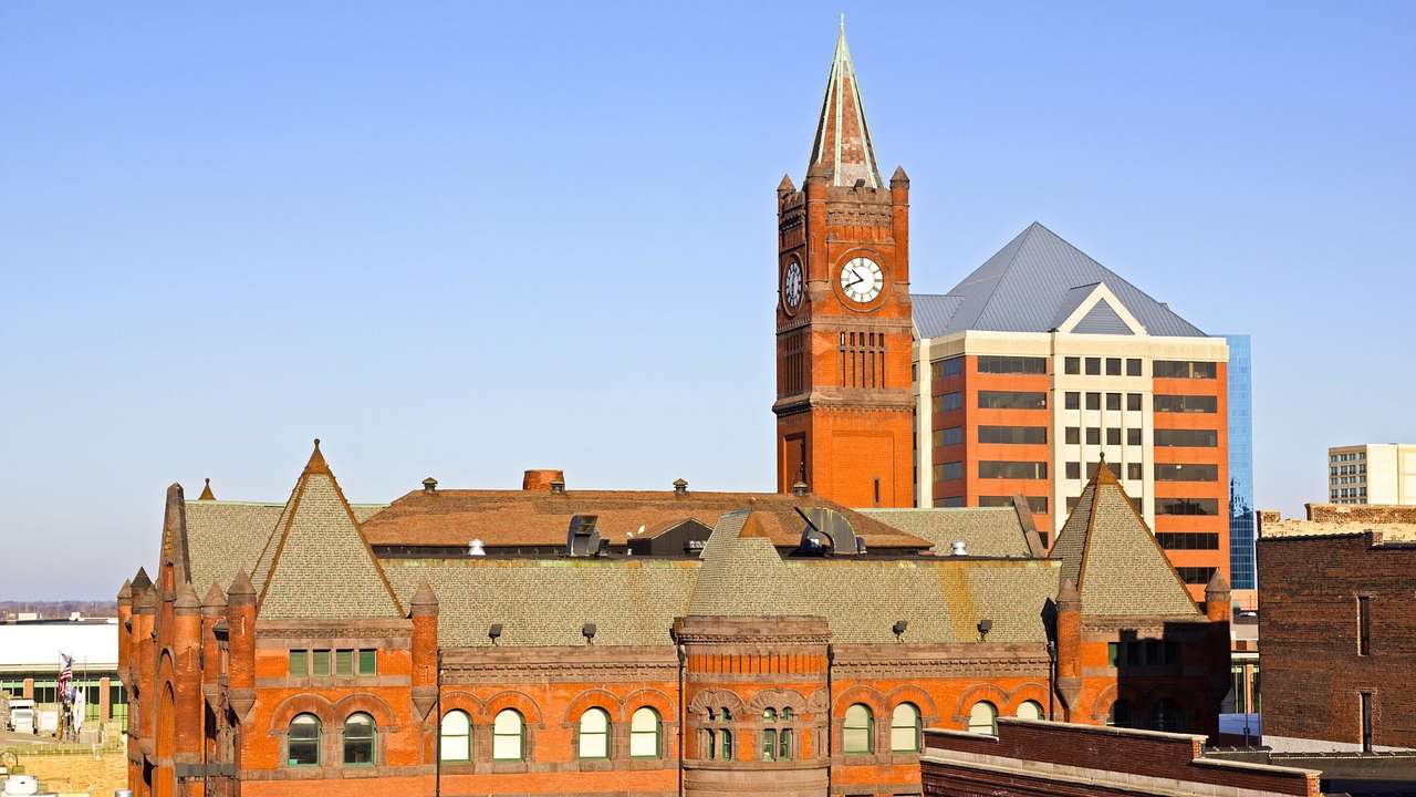 A reddish-brown building with a clock tower under a blue sky